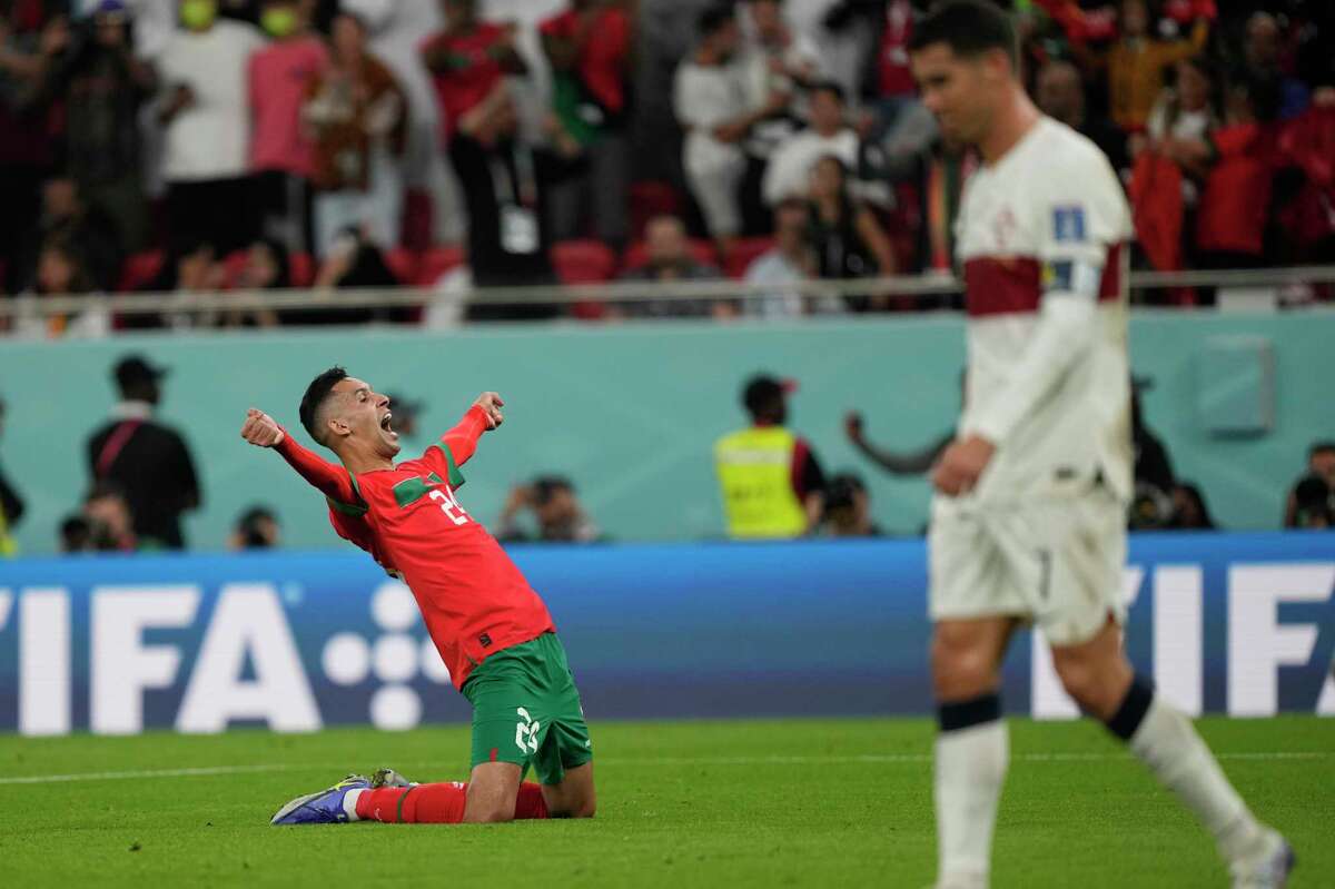 Morocco's Bilal El Khannous celebrates as Portugal's Cristiano Ronaldo leaves the pitch at the end of the World Cup quarterfinal soccer match between Morocco and Portugal, at Al Thumama Stadium in Doha, Qatar, Saturday, Dec. 10, 2022. (AP Photo/Martin Meissner)