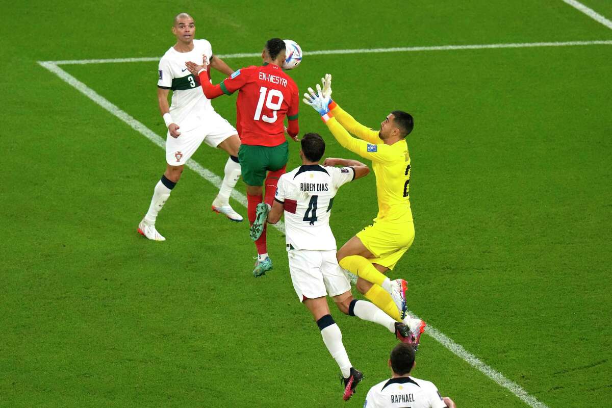 Morocco’s Youssef En-Nesyri (center) leaps for a header, the result of which was the only goal needed to lift Morocco past Portugal and into the World Cup semifinals.