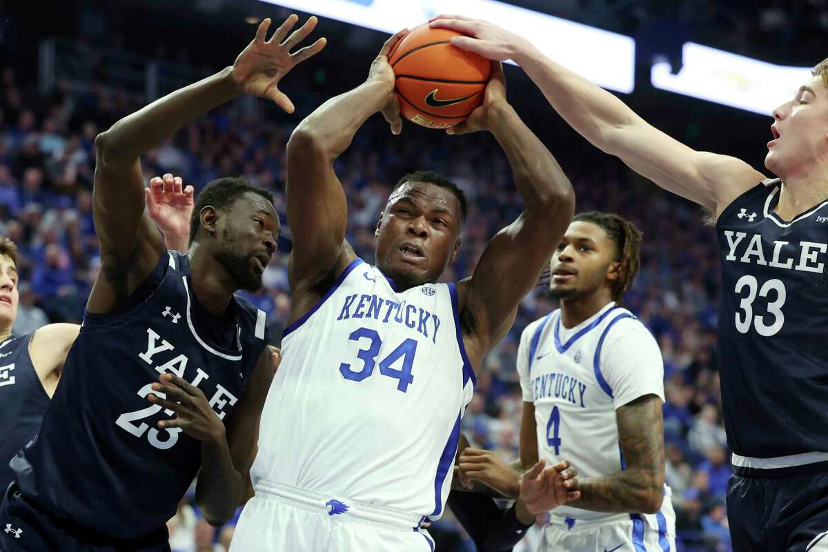 Kentucky's Oscar Tshiebwe (34) is pressured by Yale's Jack Molloy (33) and Yussif Basa-Ama (23) during the first half of an NCAA college basketball game in Lexington, Ky., Saturday, Dec. 10, 2022.