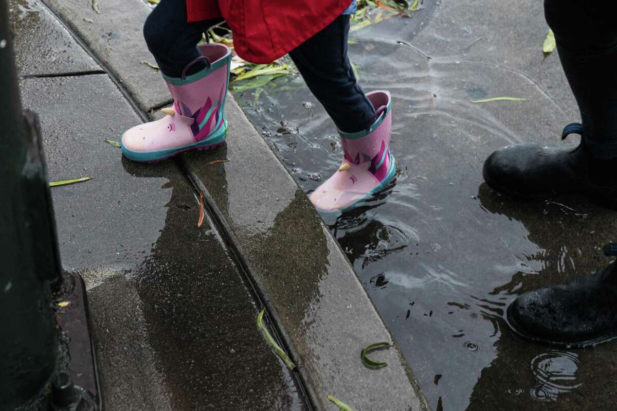 一条独角兽雨靴sloshnthrough周六在旧金山一个满溢的十字路口,12月10日,2022年。