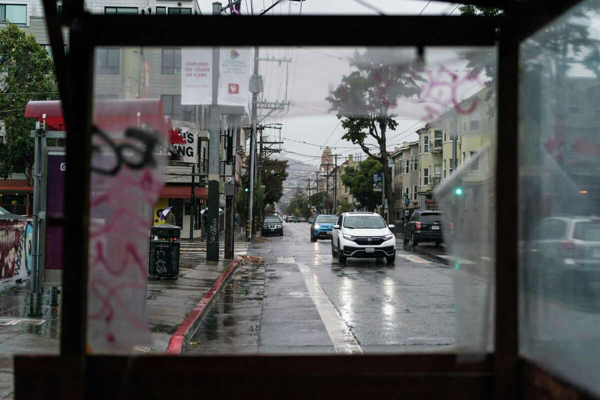 2022年12月10日，星期六，在旧金山教会区，车辆行驶在潮湿的第18街。