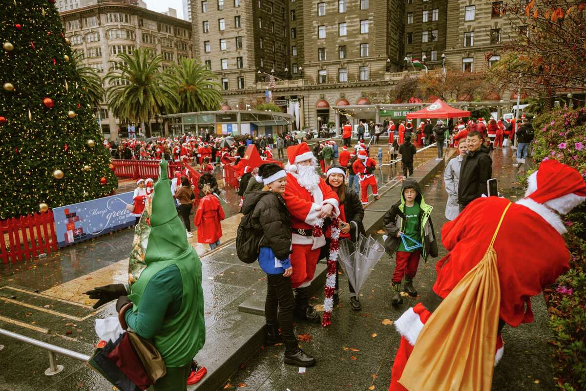 在旧金山联合广场举行的一年一度的圣诞老人节聚会上，狂欢者们展示着他们的节日精神。活动包括消防部门的玩具驱动器。
