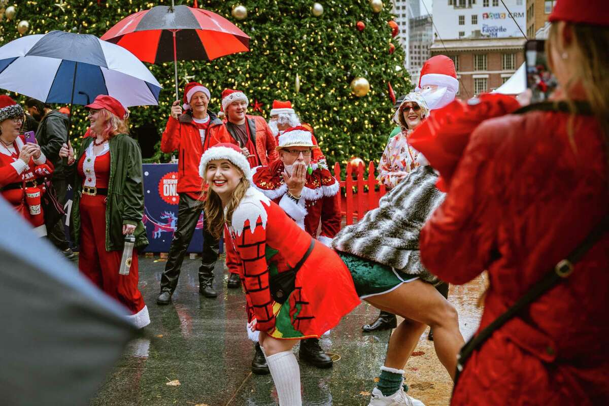 风吹雨打也没能让参加圣诞老人节的人远离在旧金山联合广场举行的庆祝活动。