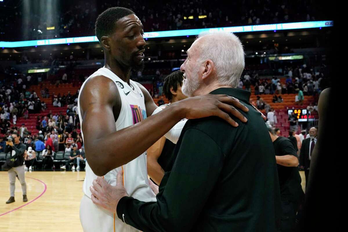 Gregg Popovich talks with Heat center Bam Adebayo after the Spurs beat the Heat 115-111 Saturday night on the 26th anniversary of Popovich taking over as coach. Popovich coached Adebayo to a gold medal at last year’s Tokyo Olympics.