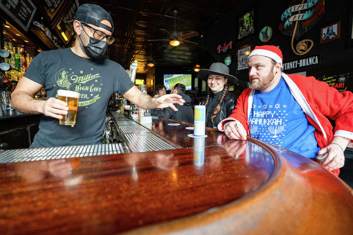 Broke Ass Stuart and his wife Kayla Brittingham have a drink at Columbus Cafe during SantaCon 2022 in Union Square in San Francisco, on Saturday, Dec. 10, 2022. 