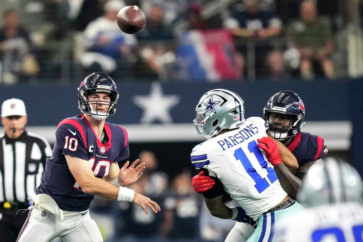 Houston Texans quarterback Davis Mills (10) throws a pass over Dallas Cowboys linebacker Micah Parsons (11) during the first half of an NFL football game Sunday, Dec. 11, 2022, in Arlington.