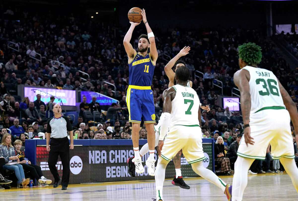 The Golden State Warriors' Klay Thompson (11) shoots and scores over the Boston Celtics' Jaylen Brown (7) and Jayson Tatum (0) during the second quarter at Chase Center on Saturday, Dec. 10, 2022, in San Francisco. (Thearon W. Henderson/Getty Images/TNS)