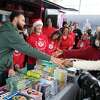 12月11日，周日，斯蒂芬·库里(左)在加州奥克兰市的桥场举行的圣诞活动中与一名年轻的球迷打招呼。这场以“冬季仙境”为主题的聚会向奥克兰500多个家庭分发了礼物，这是库里“吃、学、玩”组织的一部分。