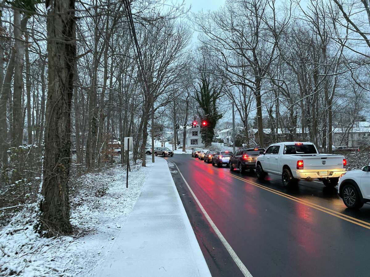 Drivers sit in morning traffic near Foran High School in Milford, Conn. on Monday, Dec. 12, 2022. The first widespread snowfall of the season brought a dusting to the area, while other regions of the state saw several inches accumulate overnight. 
