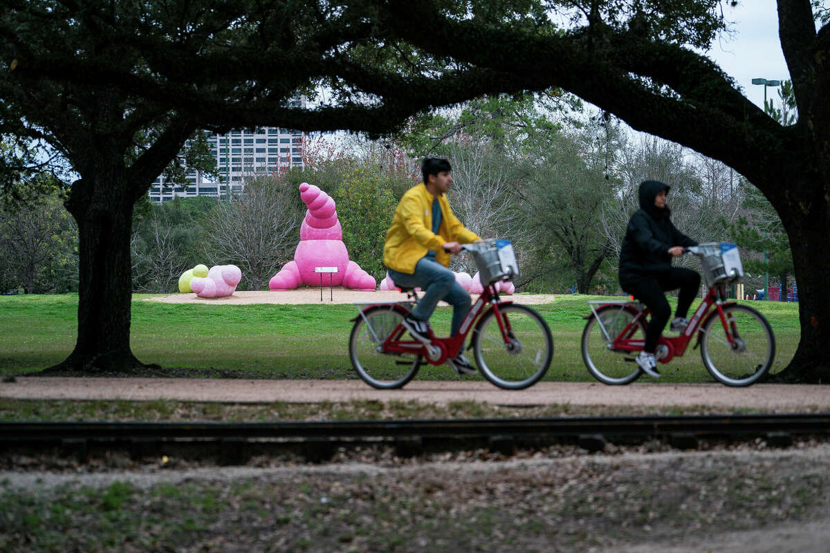 People ride bikes past the sculpture in the southwest corner of Hermann Park in 2019. A new plan calls for total redevelopment of that area of the park at Cambridge and Fannin streets including replacing the existing playground equipment.