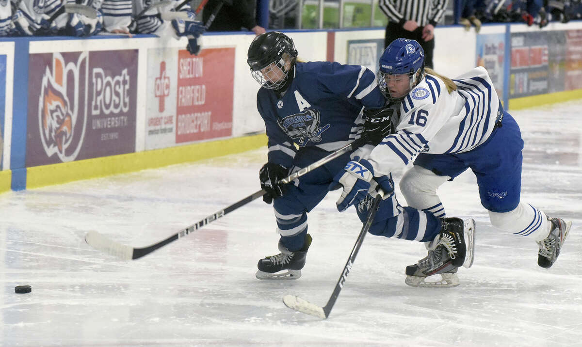 Avon's Bella Bonfiglio (15) and Darien's Gretchen Edwards (16) battle for the puck during the CHSGHA girls ice hockey semifinals in Shelton on Saturday, March 5, 2022.