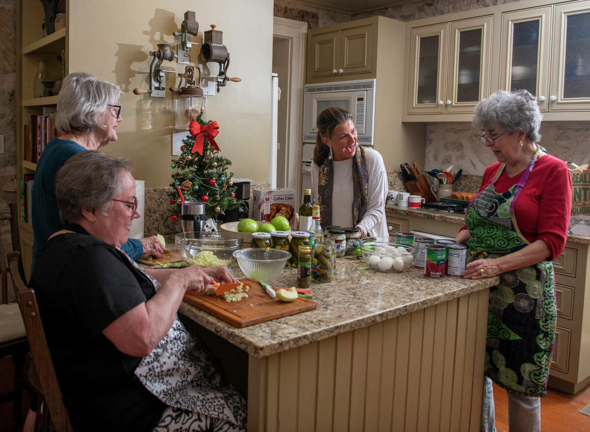 Carol Groos, top left, Nancy Turner, bottom left, Lorrie Uhl, center, and Maria Pfeiffer prep ingredients for a herring salad. Getting together to make it is an opportunity to see far-flung family members.