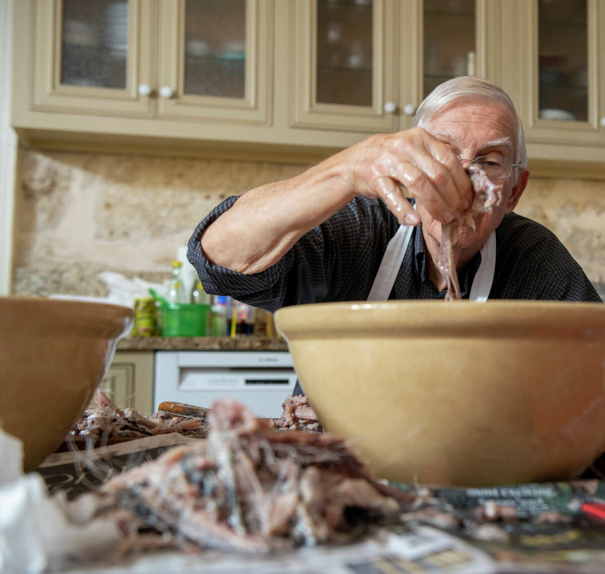 Fred Pfeiffer prepares herring for a herring salad, a German dish typically prepared and served during the Christmas season.