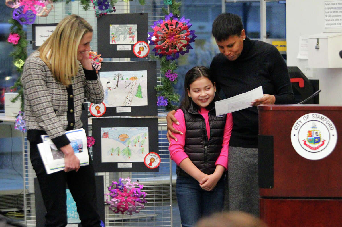 Stamford Mayor Caroline Simmons, left, looks on as Cyara Cortez, 10, from Westover Elementary School is recognized by Superintendent Dr. Tamu Lucero for her greeting card design during Stamford Public Schools Seasonal Greeting Card Contest Award Presentation at the Stamford Government Center Lobby in Stamford, Conn., on Tuesday December 13, 2022.