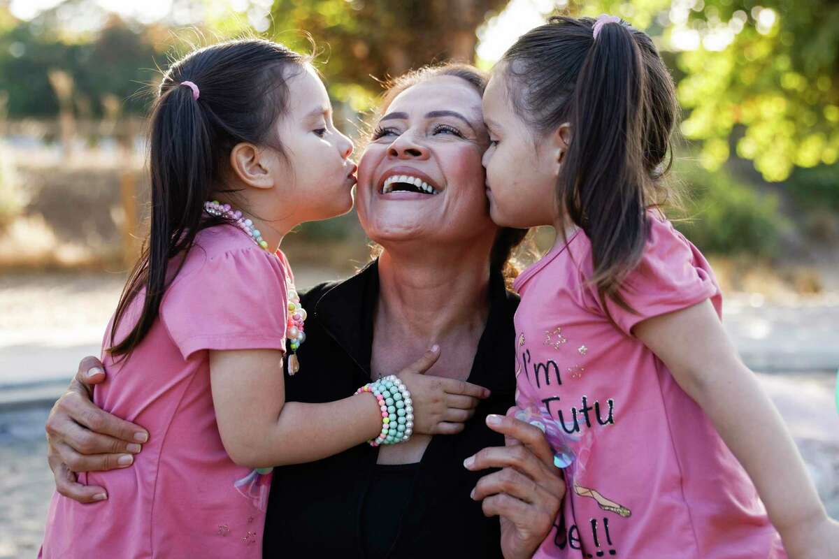 Leticia Cervantes is kissed by twin granddaughters Athena (left) and Altheia in San Mateo. Cervantes benefited from The Chronicle’s Season of Sharing Fund.