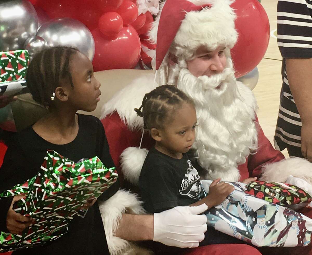 Center Jakob Poeltl played Santa Claus on Tuesday, Dec. 13, 2022, at a Spurs holiday party at the AT&T Center, where he handed out gifts to families from San Antonio's economically challenged East Side.