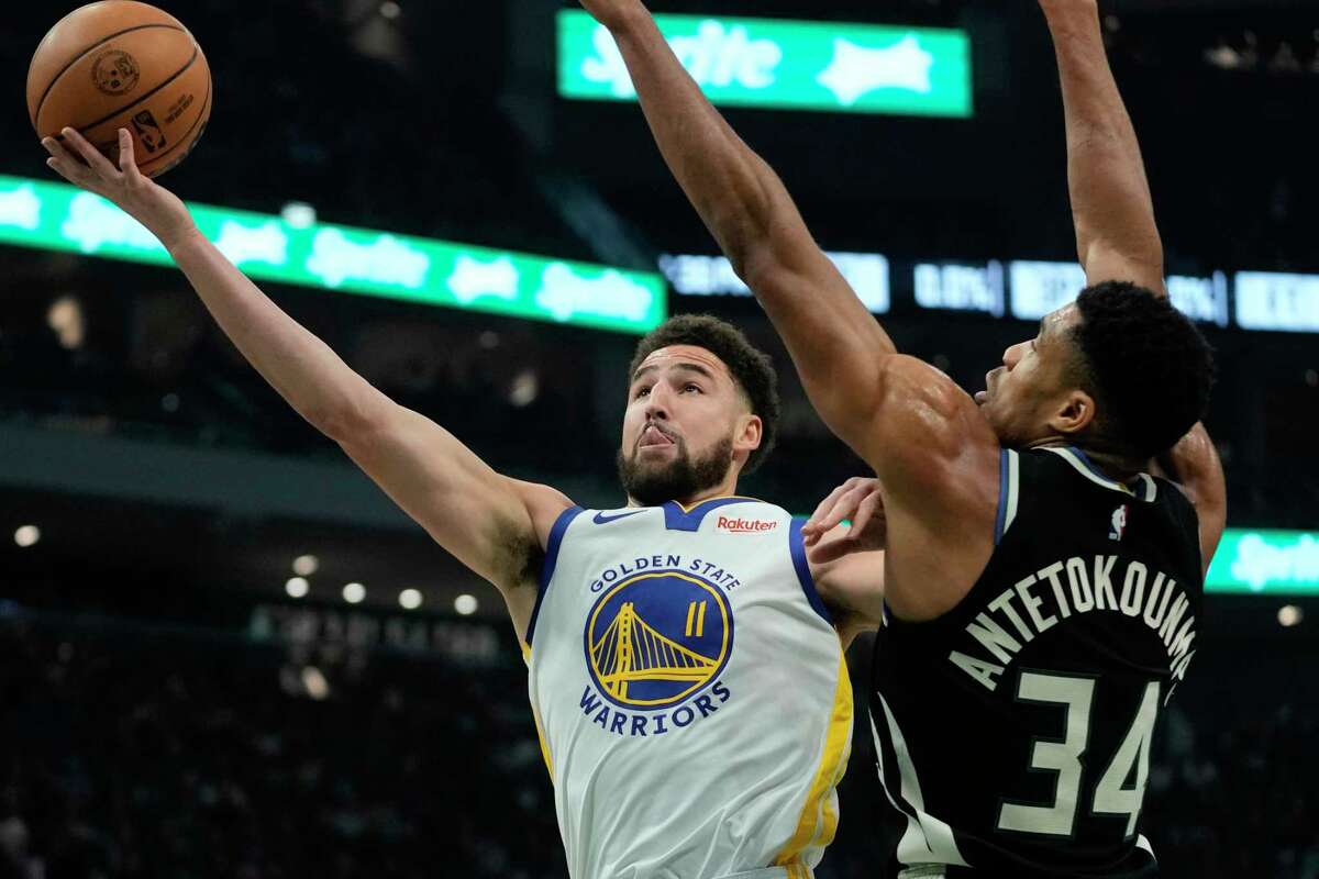 Golden State Warriors' Klay Thompson shoots past Milwaukee Bucks' Giannis Antetokounmpo during the first half of an NBA basketball game Tuesday, Dec. 13, 2022, in Milwaukee. (AP Photo/Morry Gash)