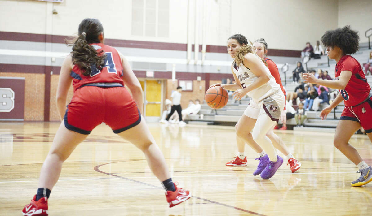 Legacy guard Jazmyn Johnson dribbles while being defended by Plainview's Mady Williams (right) and Kamila Macedo (left) during a Dec. 13 girls basketball game at Rebel Gymnasium. 