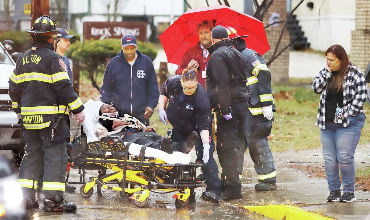 John Badman|The Telegraph Rescue workers prepare an Alton Middle School student for transport to the hospital Wednesday afternoon after he was struck by a vehicle on College Avenue in front of the school. 