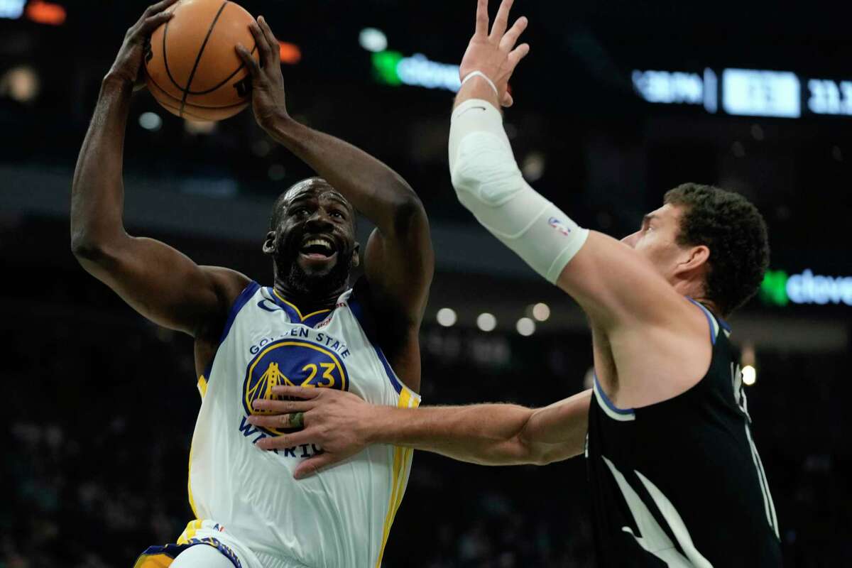 Golden State Warriors' Draymond Green shoots past Milwaukee Bucks' Brook Lopez during the first half of an NBA basketball game Tuesday, Dec. 13, 2022, in Milwaukee. (AP Photo/Morry Gash)