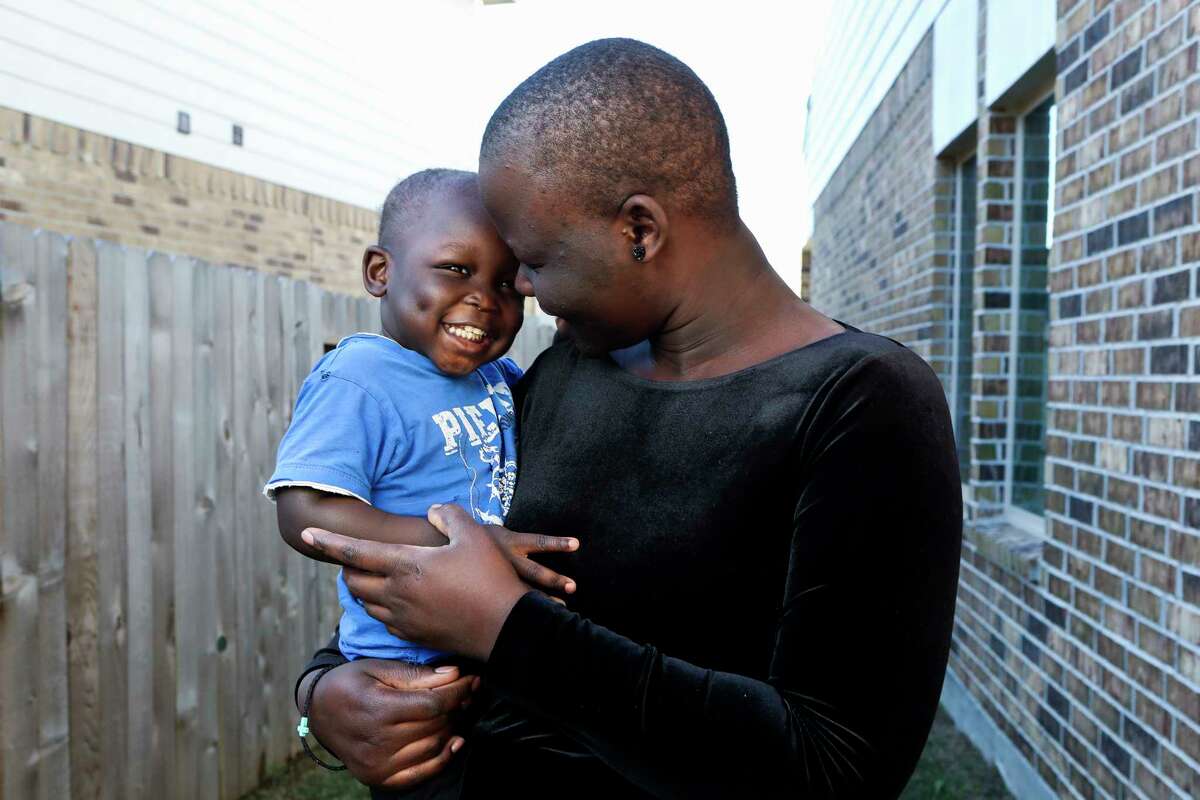 Longar Wol, 2, laughs in the arms of his mother, Monika Kiir, in their backyard, Thursday, Dec. 15, 2022, in Conroe. Longar, has the same smile of his father, Makuac "Gabriel" Gony Wol, Monika Kiir said. Makuac, who was one of the original Lost Boys of Sudan who came to The Woodlands 20 years ago, died of cancer on Nov. 30.