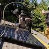 工人Luminalt工作的屋顶上安装太阳能电池板7月在门洛帕克回家。