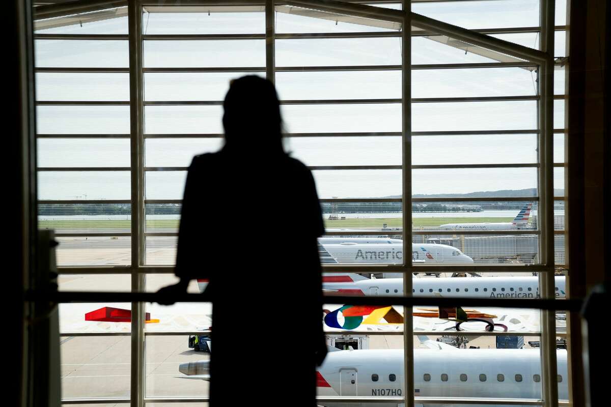 A traveler looks out at American Airlines planes at Ronald Reagan Washington National Airport in Arlington, Virginia, on July 2, 2022. - US airlines are bracing customers for what will probably be a bumpy Fourth of July holiday weekend as the industry struggles to manage a surge in travel demand that probably exceeds its current capacity. Flight delays and cancellations created a difficult start for many travelers leaving town for the holiday. (Photo by Stefani Reynolds / AFP) (Photo by STEFANI REYNOLDS/AFP via Getty Images)