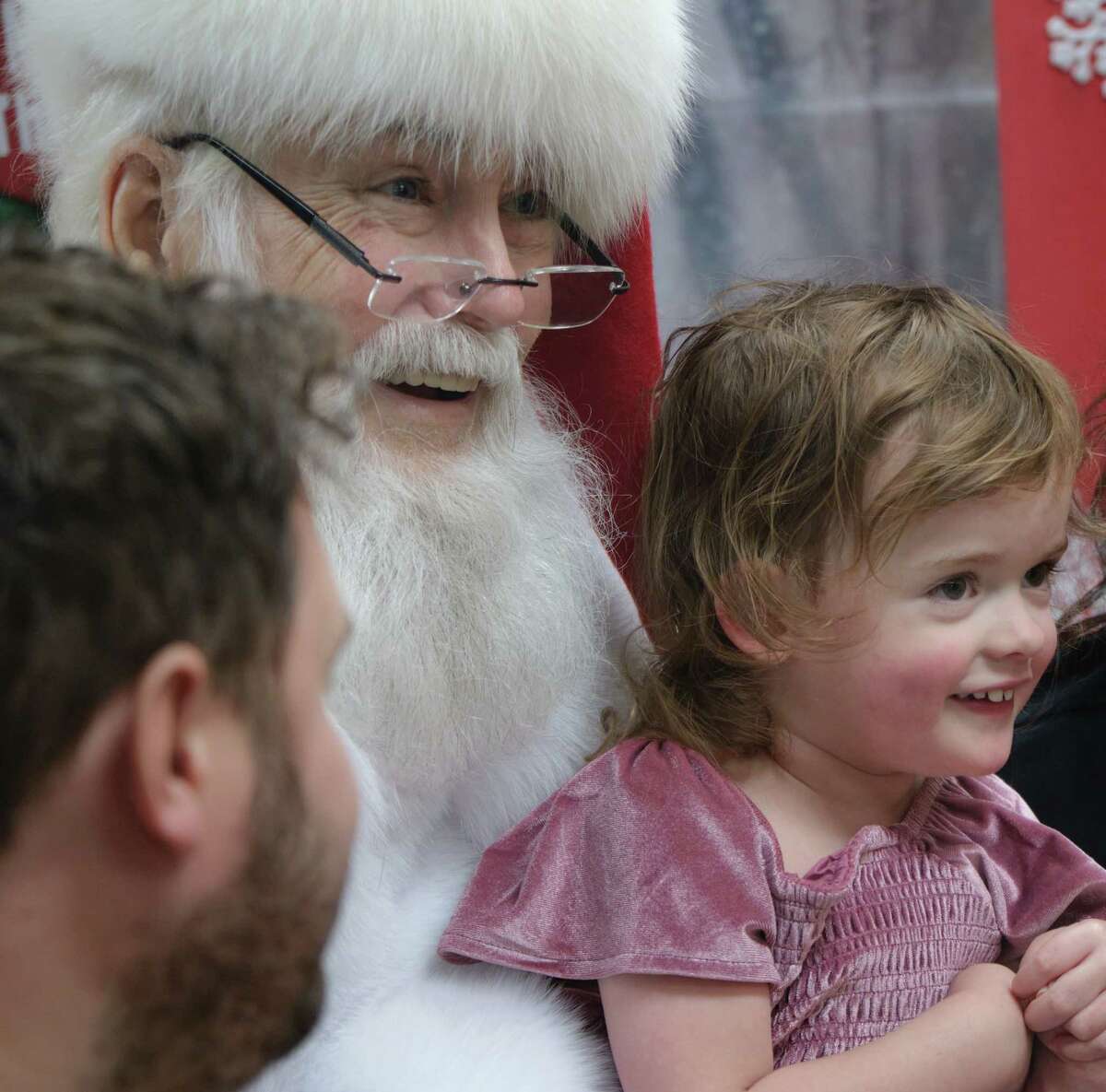 in {The Woodlands}, {Thursday}, {December} {15}, {2022.} During their visit to see Santa at TIRR Memorial Hermann in The Woodlands, Vivienne Lee (R) smiles with Santa, Deryl McKenzie (C). December 15, 2022