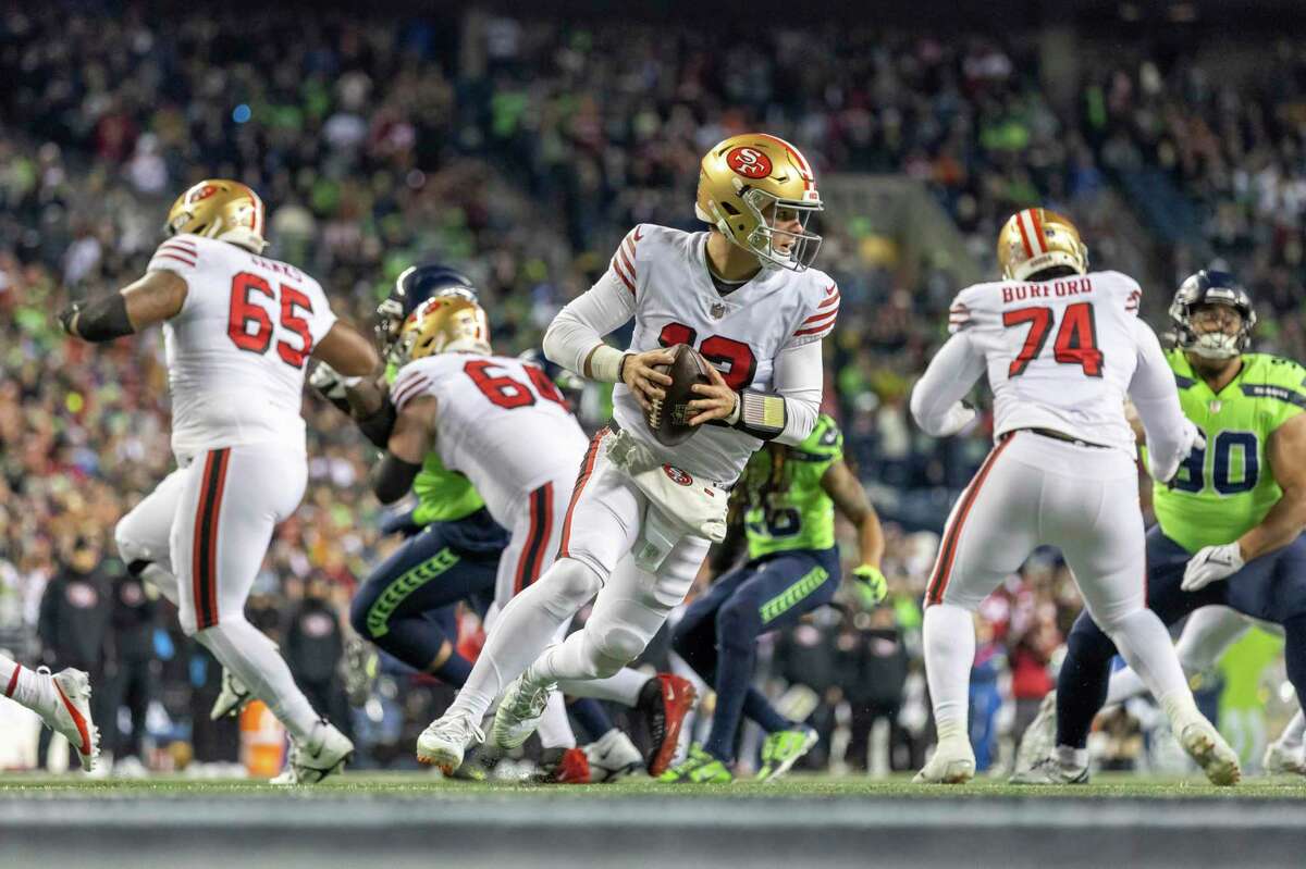 2022年12月15日，星期四，在华盛顿州西雅图，旧金山49人队四分卫布洛克·珀迪(13岁)在NFL橄榄球比赛中对阵西雅图海鹰队。(美联社图片/杰夫·刘易斯)