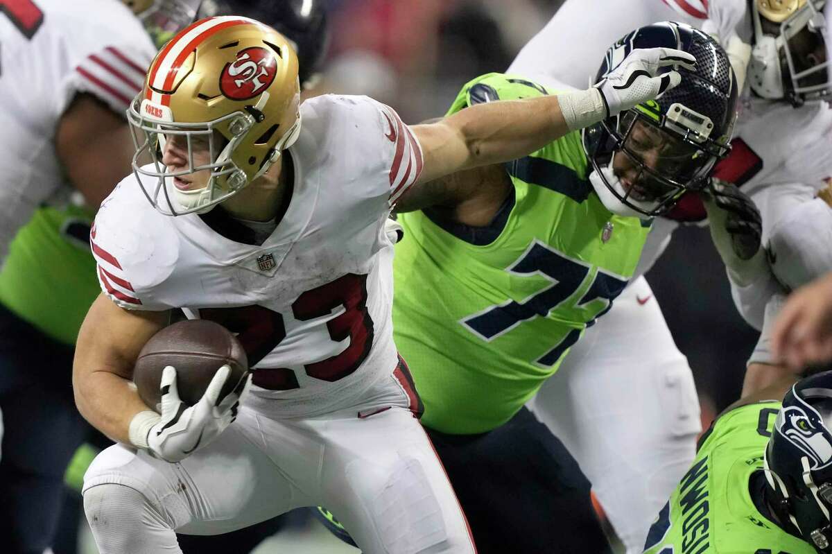 San Francisco 49ers running back Christian McCaffrey (23) runs against Seattle Seahawks defensive tackle Quinton Jefferson during the second half of an NFL football game in Seattle, Thursday, Dec. 15, 2022. (AP Photo/Stephen Brashear)