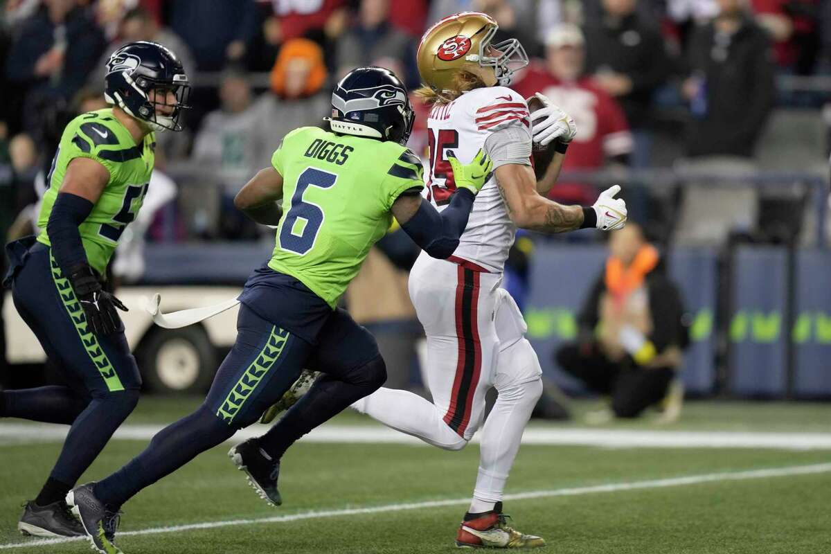 San Francisco 49ers tight end George Kittle (85) walks on the field wearing  a Crucial Catch hoody before an NFL football game against the Seattle  Seahawks, Sunday, Oct. 3, 2021 in Santa