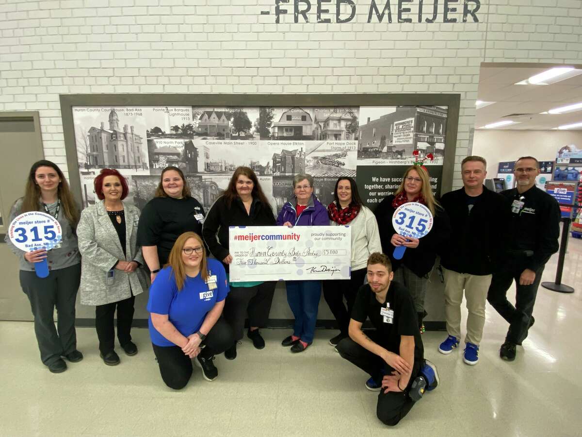 Lisa Sarka and Leta Bambach pose with Bad Axe Meijer employees and the $5,000 donation check.