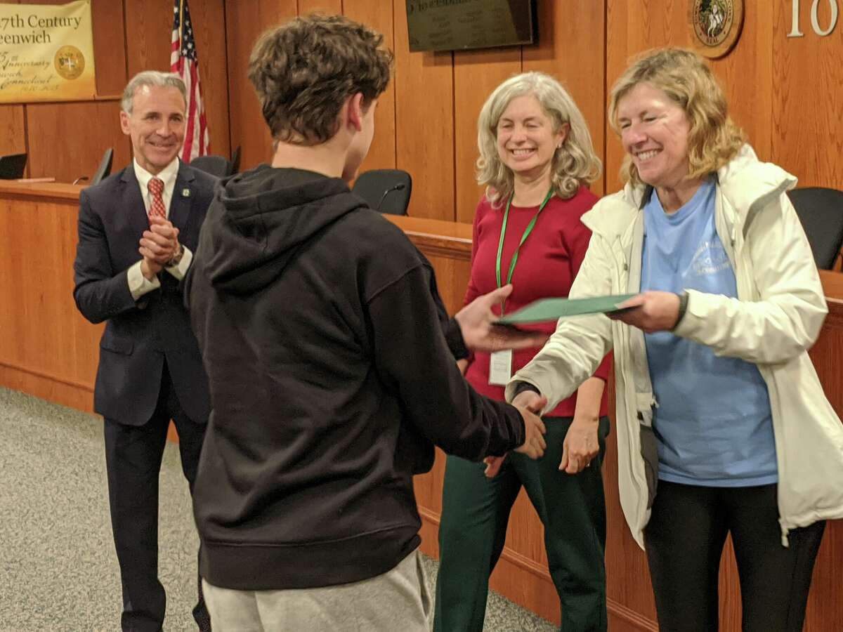 First Selectman Fred Camillo, Selectperson Janet Stone McGuigan and Selectwoman Lauren Rabin, at right, congratulated the championship boys soccer team at Town Hall. A proclamation was read in the team's honor and the players were given certificates of achievement, including Nathan Leipin.