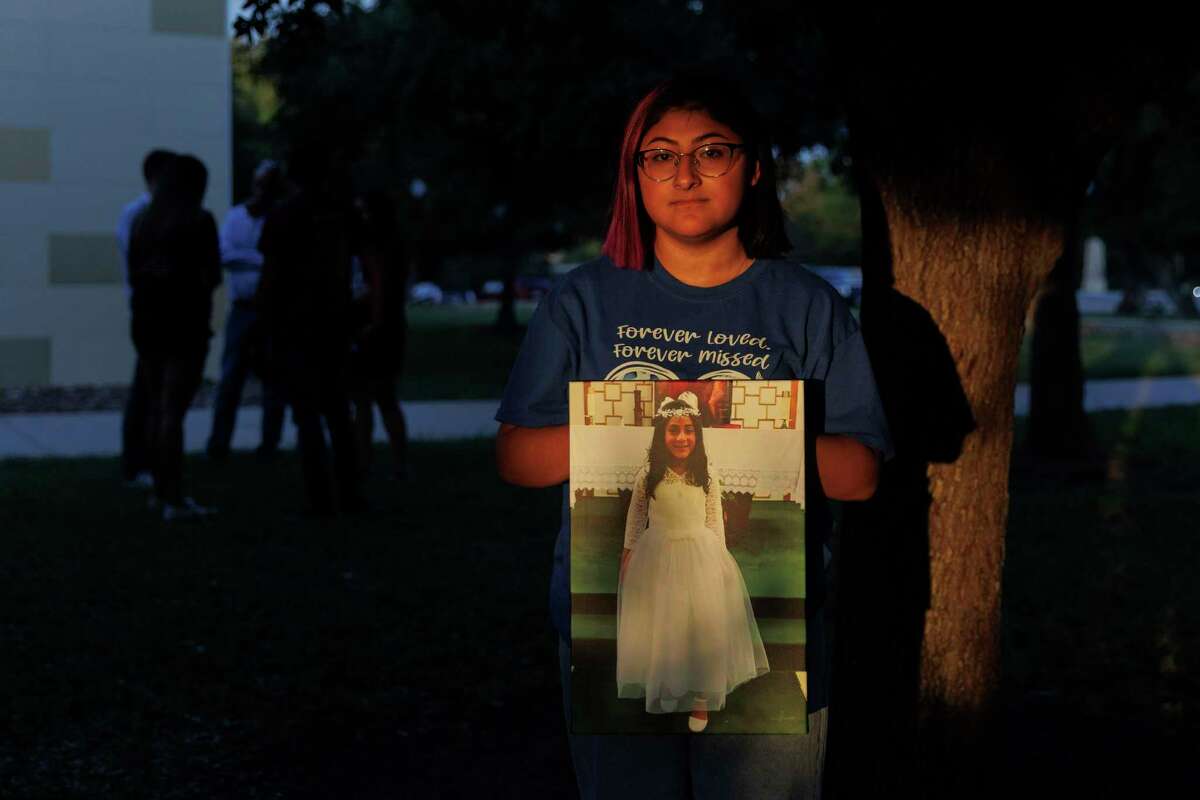 Jazmin Cazares, 17, stands with an image of her 9-year-old sister Jackie Cazares, who was murdered in the Robb Elementary School mass shooting. Unanswered questions about her sister’s final moments haunt her.
