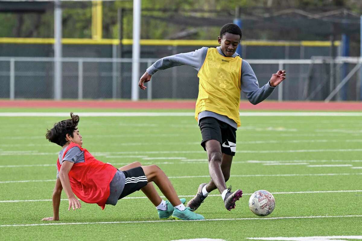 A Cypress Creek varsity soccer player (right yellow) controls the ball during practice at Cypress Creek High School in Houston, Texas on Friday, December 6, 2022.