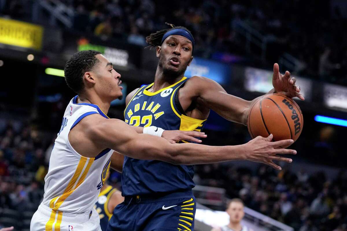 Golden State Warriors guard Jordan Poole (3) tries to pass around Indiana Pacers center Myles Turner (33) during the first half of an NBA basketball game in Indianapolis, Wednesday, Dec. 14, 2022. (AP Photo/Michael Conroy)
