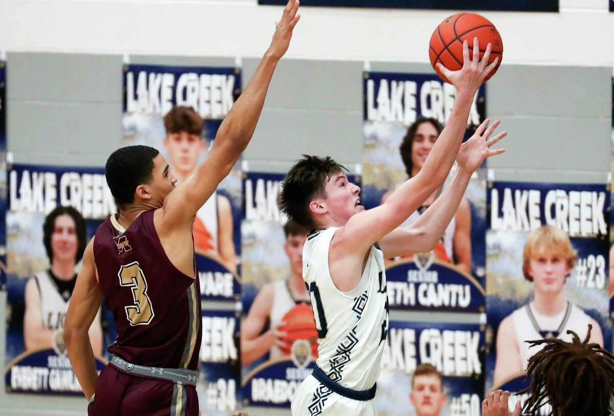 Lake Creek's Braedon Bigott (20) shoots past Magnolia West's Brandon Taylor (3) in the third quarter of a District 21-5A high school basketball game at Lake Creek High School, Friday, Dec. 16, 2022, in Montgomery.