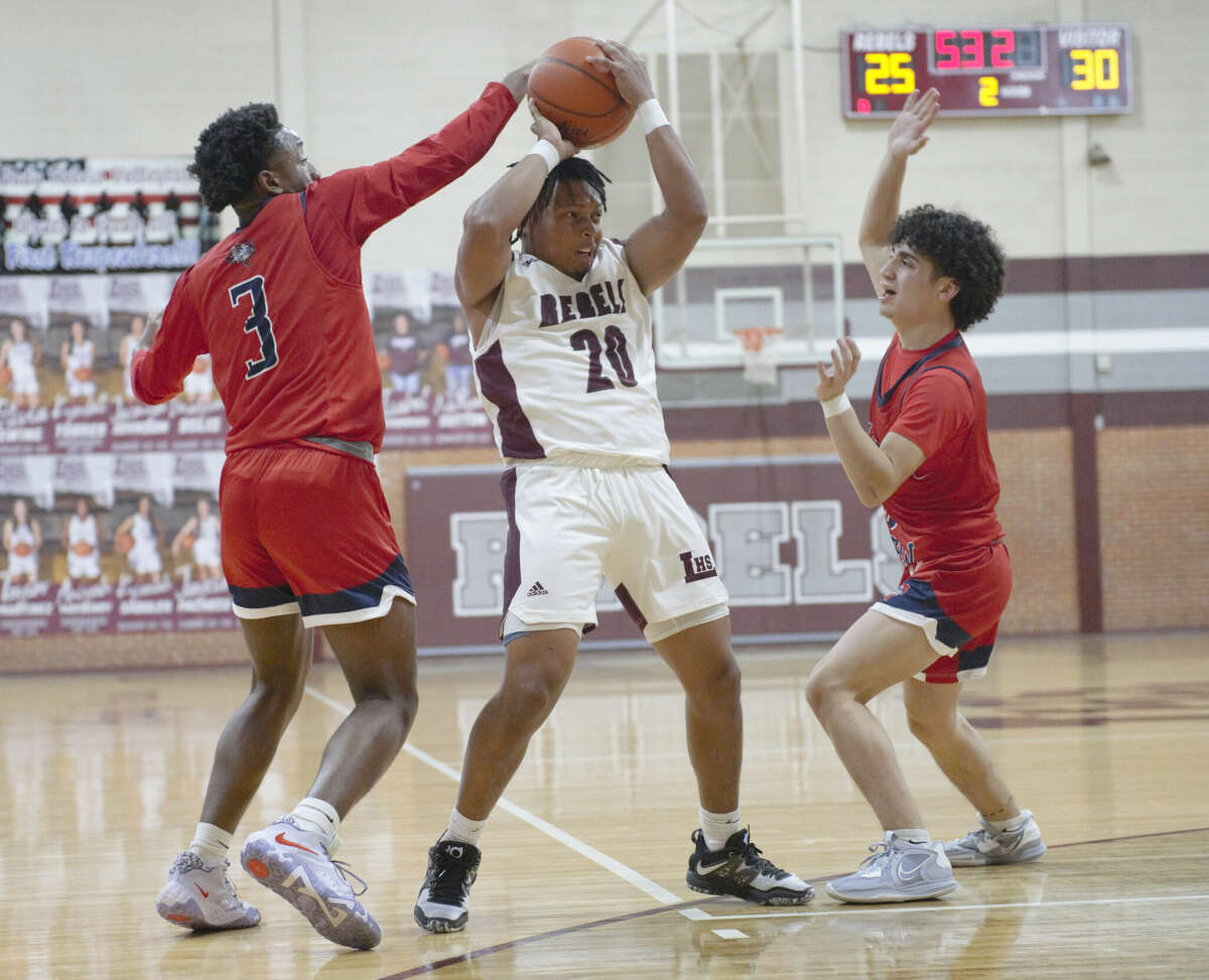 Legacy's Tommy Johnson tries to keep the ball away from Plainview defenders Jacobi Porter (left) and Ethan Mendoza during a Dec. 16 basketball game at Rebel Gymnasium. 