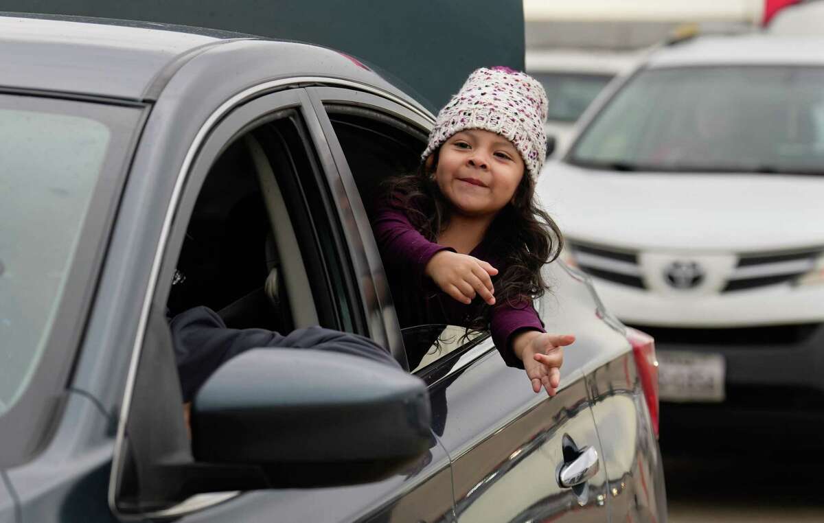 Laney Cortez reaches toward the volunteers and firefighters while her family is waiting to receive toys at Houston Fire Department’s Operation Stocking Stuffer Saturday, Dec. 17, 2022, at Dick Graves Park in Houston. The operation provides toys for more than 30,000 children in the greater Houston area each year, acoording to HFD.