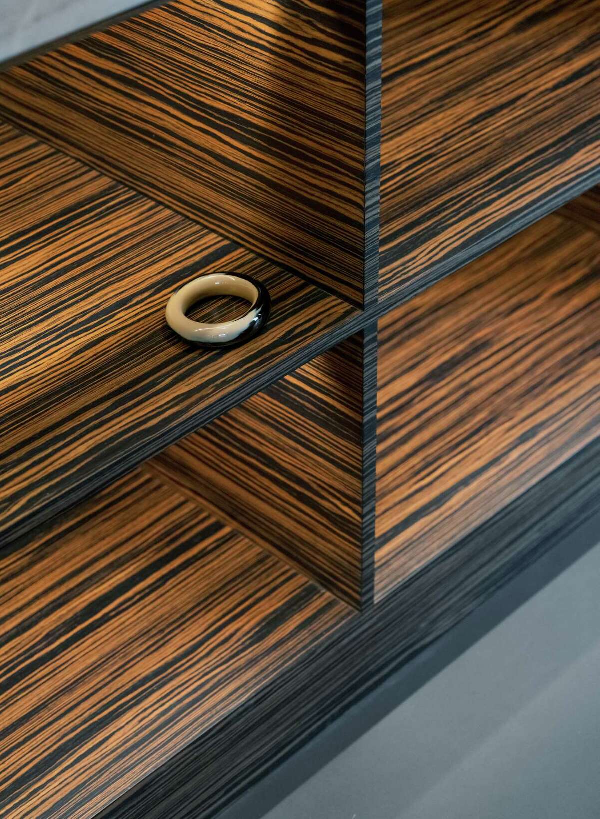The contemporary kitchen cabinets are covered with a veneer of Macassar Ebony, an exotic wood grown in Southeast Asia and featuring a dramatic striped pattern. 