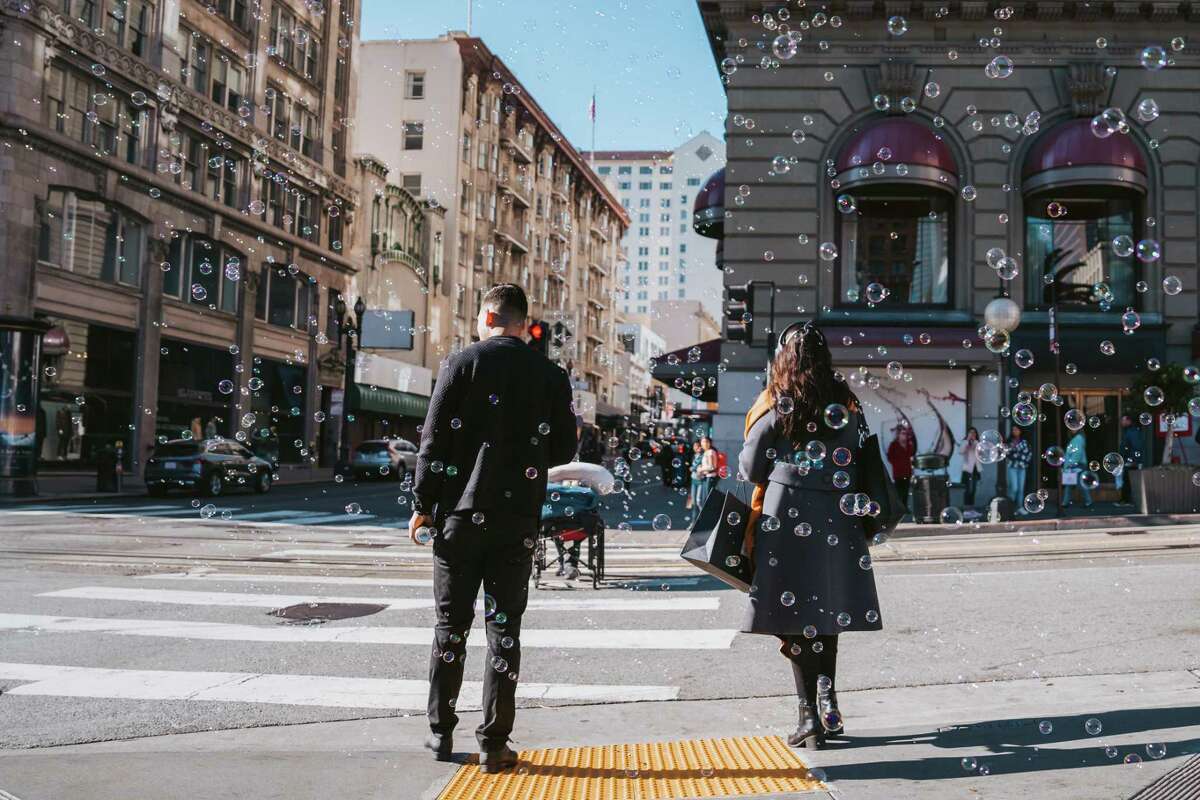 Shoppers walk past the Louis Vuitton store at Union Square in San