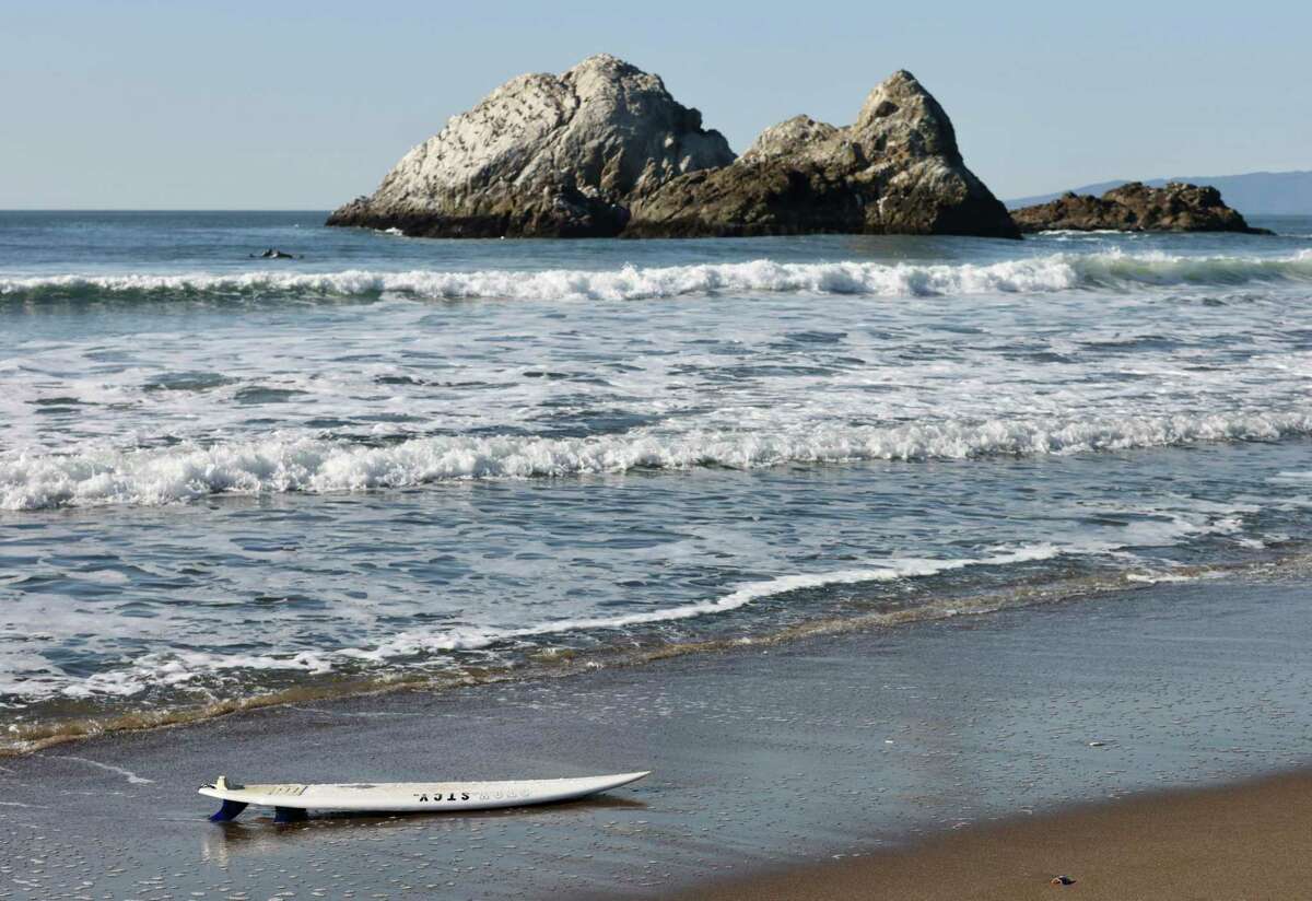 A surfboard washes to the shore Saturday at Ocean Beach, where a couple saved a surfer from near drowning early this month.
