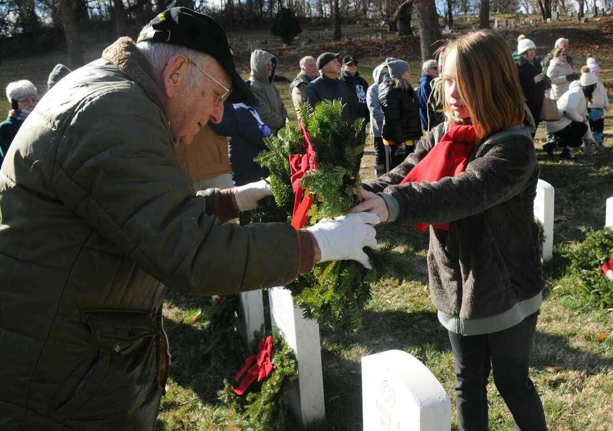 On Saturday, 99-year-old World War II veteran Art Williams and 11-year-old Emma Crews worked in tandem to place wreaths during Saturday's ceremony at Alton National Cemetery.  
