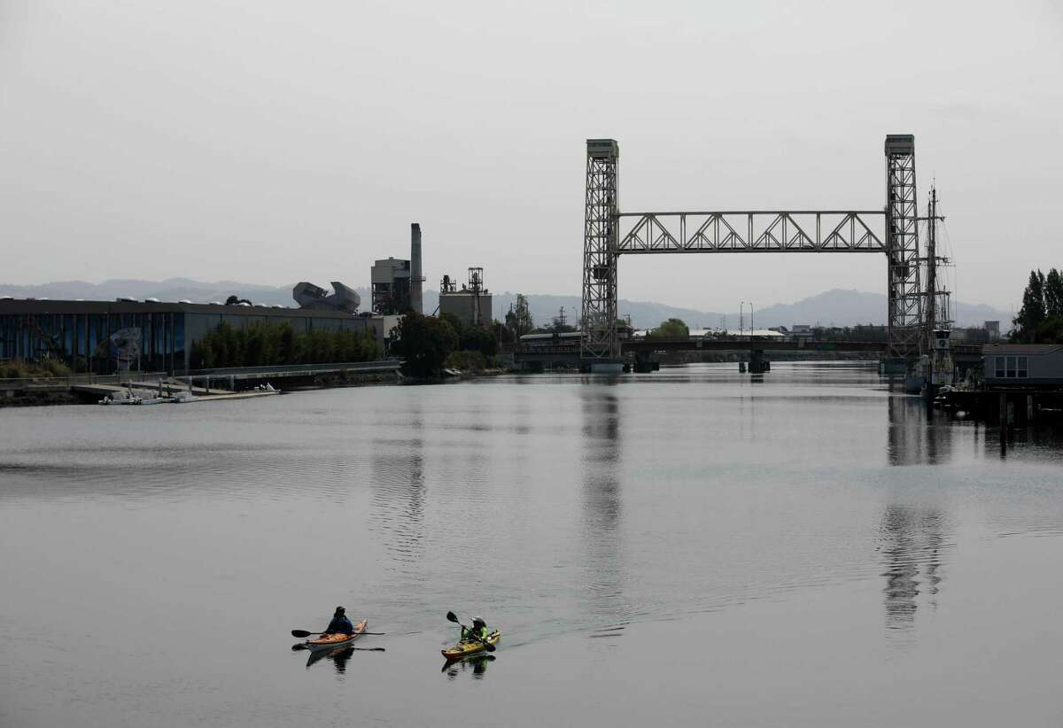 Kayakers brave smog as they paddle through the Tidal Canal in Alameda in 2021. The Bay Area Air Quality Management District issued a Spare the Air alert for Monday.