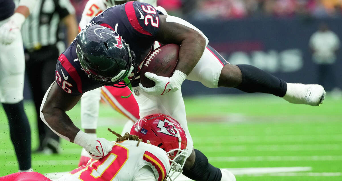 Houston Texans running back Royce Freeman (26) leaps over Kansas City Chiefs safety Justin Reid (20) while running the ball during the fourth quarter of an NFL game Sunday, Dec. 18, 2022, at NRG Stadium in Houston.