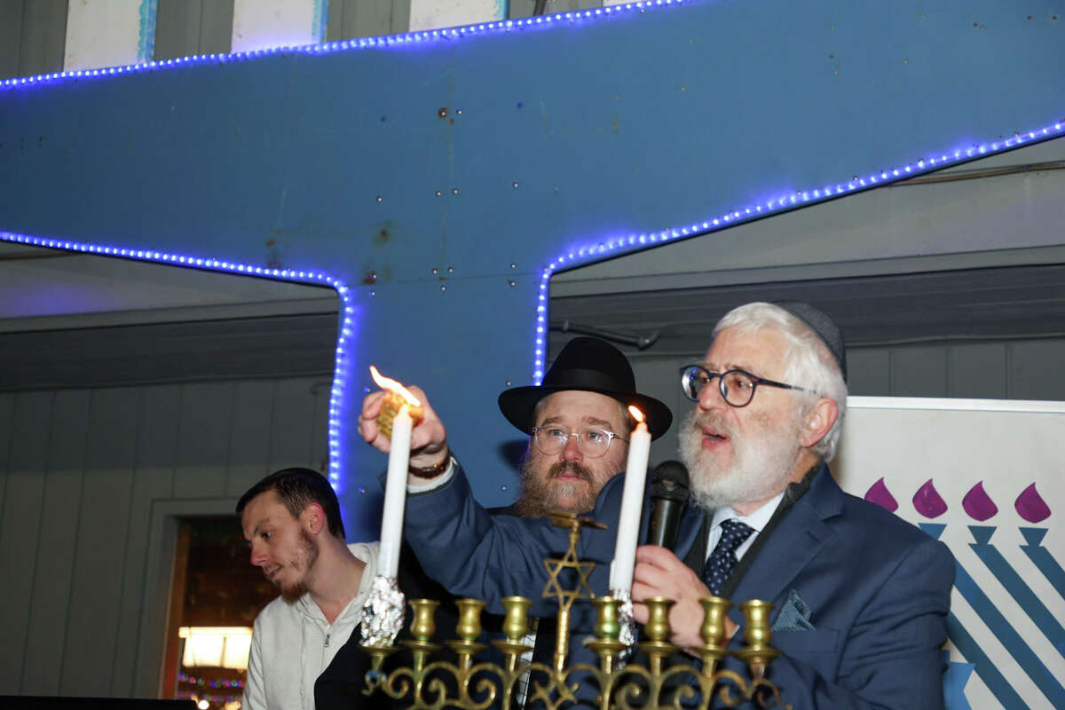 Rabbi Yehoshua Hecht, of Beth Israel of Westport/Norwalk, leads the ceremony to light the 18-foot tall menorah at the start of Hanukkah Sunday at Stew Leonard's in Norwalk.