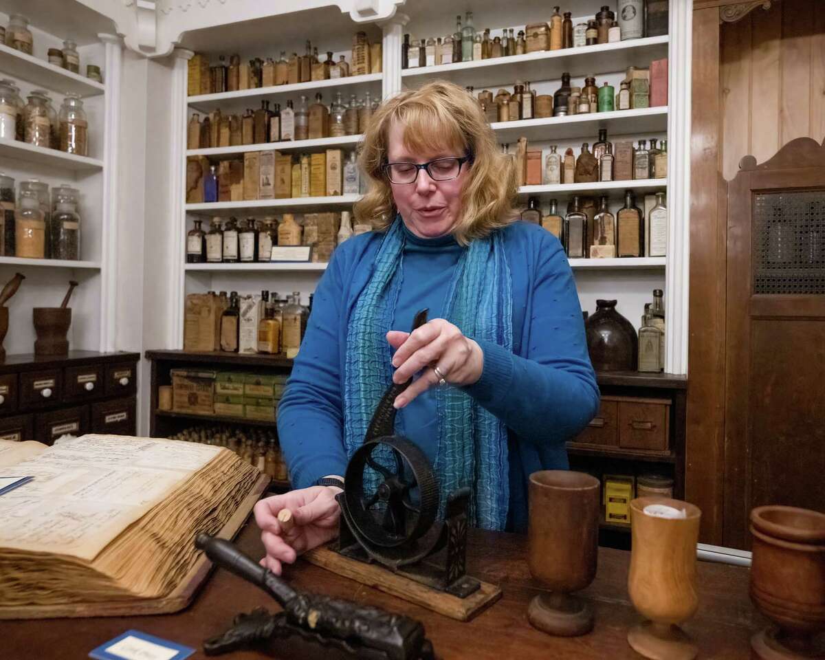 Lee Anna Obos, curator of the Throop Museum, demonstrates a machine that makes corks fit into bottles on the Albany College of Pharmacy and Health Sciences campus on Friday, Dec. 9, 2022, in Albany, NY. (Jim Franco/Times Union)