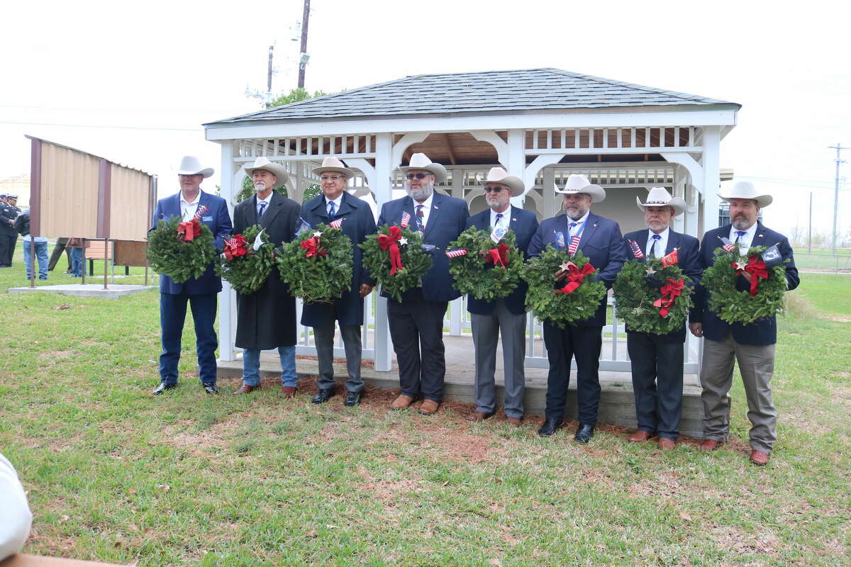 Eight members of The Sons of the Republic of Texas pose with some of the wreaths that were placed at the grave sites of military veterans at Crown Hill Cemetery.