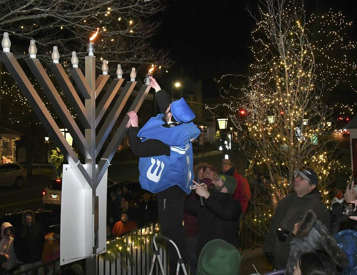 Avremi Elberg, a volunteer with Yeshiva of New Haven lit the menorah at the Chanukah Village Walk in Ridgefield on Sunday, Dec. 18, 2022. 
