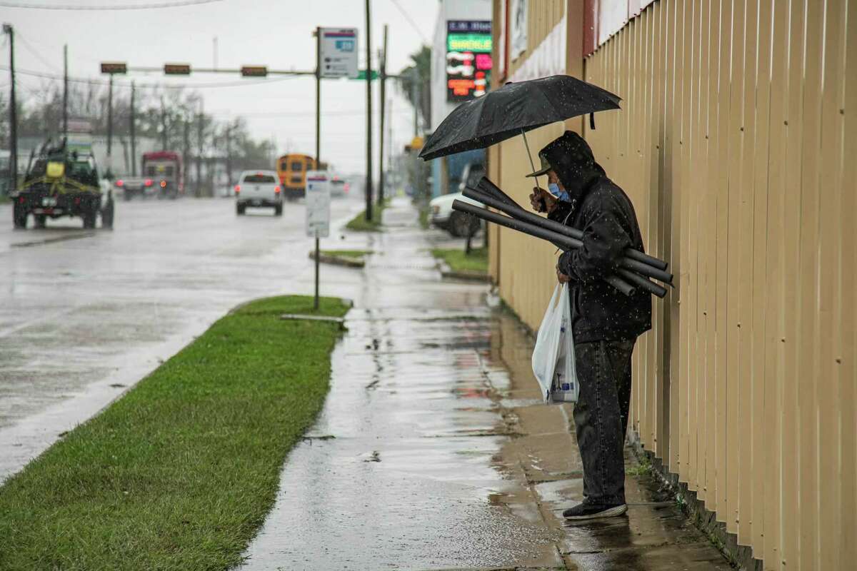 Richard Tano waits for the autobus  arsenic  helium  braves the acold  and rainy upwind  to get   tube  insulation for his location  successful  mentation  for the dropping somesthesia  connected  Monday, Dec. 19, 2022 successful  Houston.